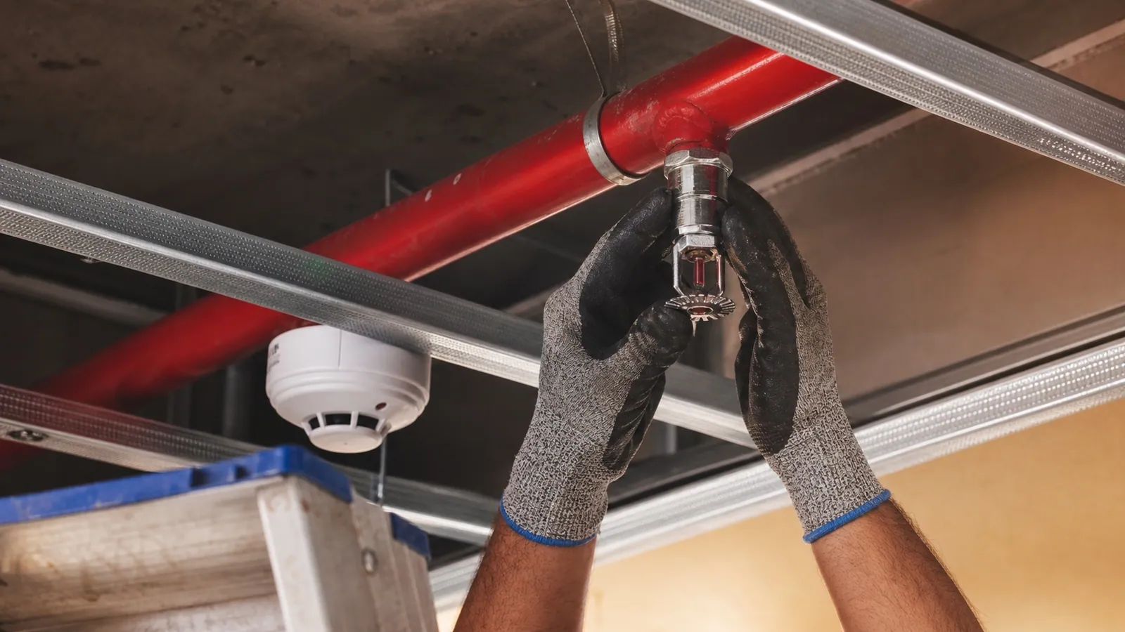 Fire sprinkler and smoke detector installation being inspected inside a Dubai commercial fit-out